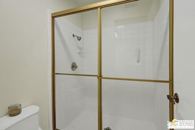 bathroom featuring toilet and walk in shower