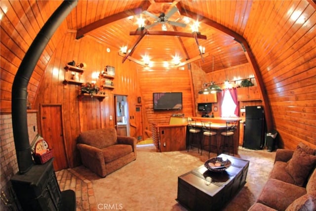 living room with carpet flooring, a wood stove, lofted ceiling with beams, and wooden ceiling