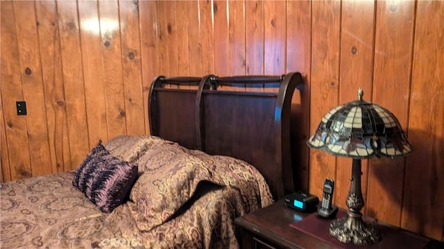 bedroom featuring wooden walls