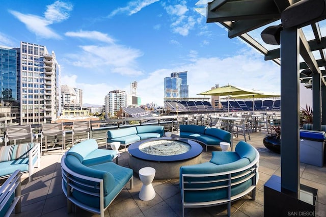 view of patio with an outdoor living space with a fire pit