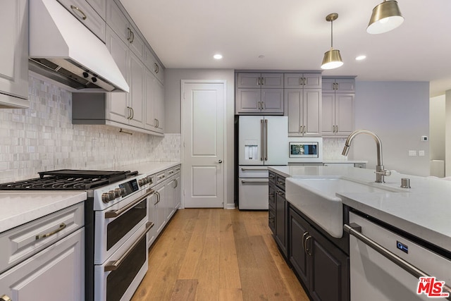 kitchen with gray cabinets, sink, appliances with stainless steel finishes, and light hardwood / wood-style flooring