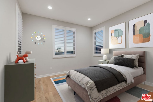 bedroom featuring multiple windows and light hardwood / wood-style floors