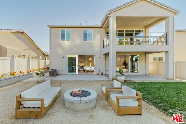 rear view of property featuring a patio, a balcony, an outdoor fire pit, and cooling unit