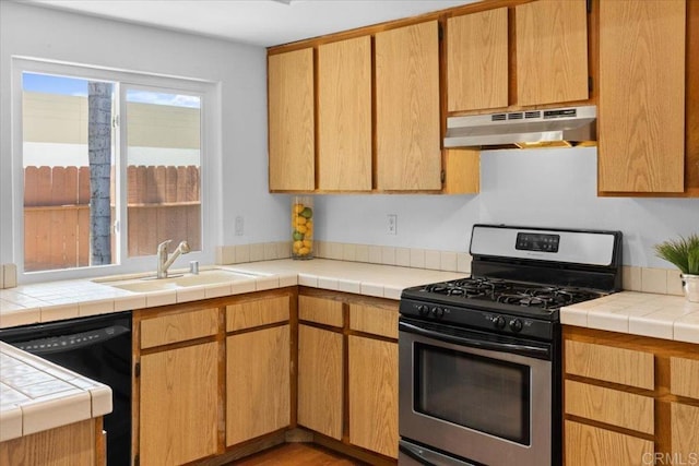 kitchen with dishwasher, gas stove, tile countertops, and sink