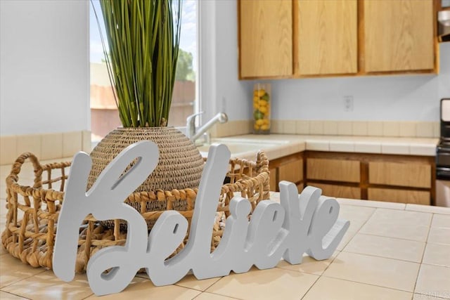 kitchen with tile countertops, sink, and light tile patterned floors