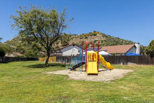 view of play area with a mountain view and a lawn