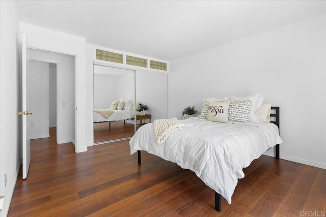 bedroom with dark wood-type flooring and a closet