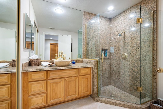 bathroom featuring tile patterned floors, a shower with door, and vanity