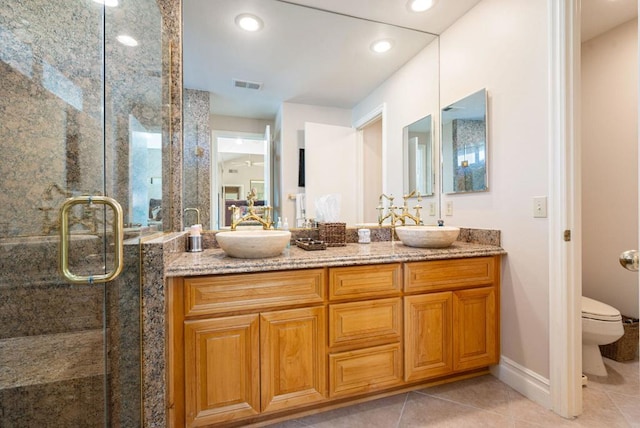 bathroom featuring toilet, tile patterned flooring, walk in shower, and vanity