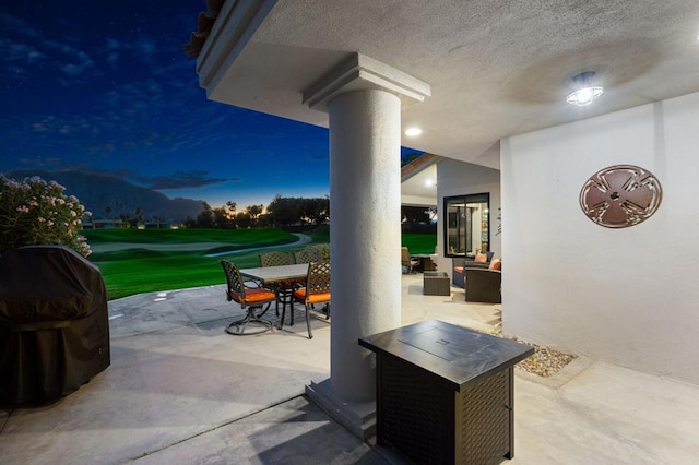 patio terrace at dusk with an outdoor hangout area, a yard, and a grill