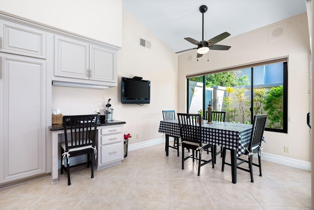 dining area featuring ceiling fan, light tile patterned floors, and vaulted ceiling