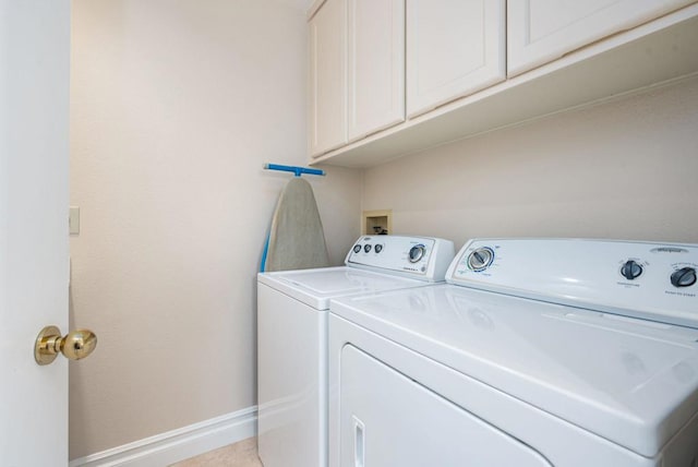 clothes washing area featuring cabinets and independent washer and dryer