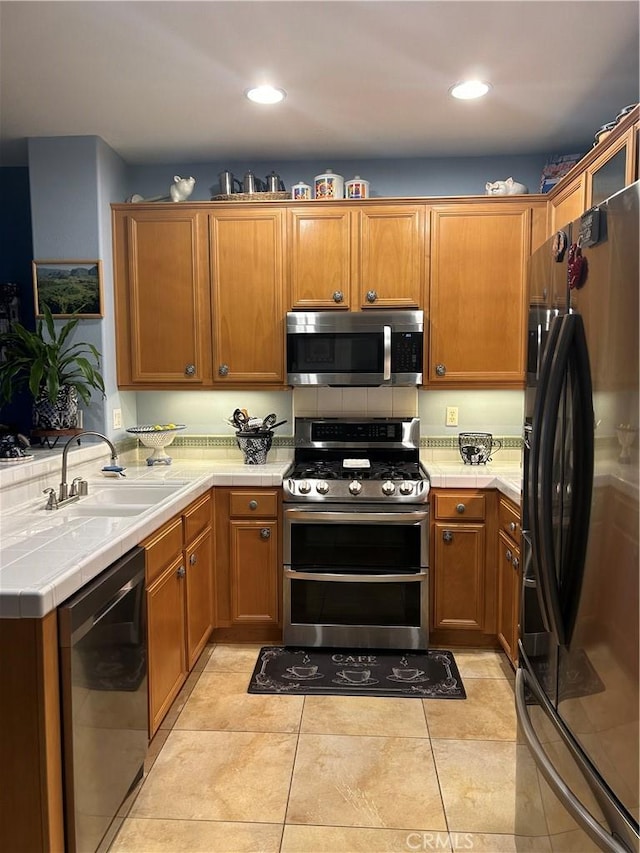 kitchen featuring light tile patterned floors, sink, and appliances with stainless steel finishes