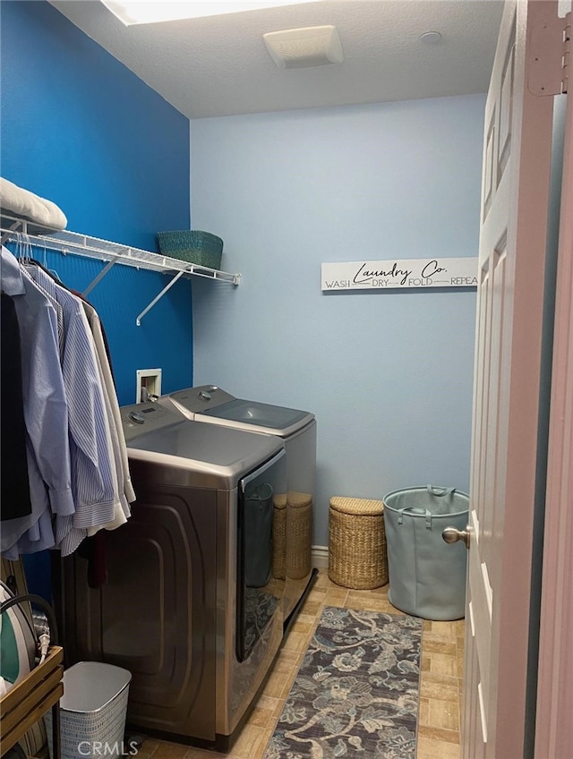 laundry room with washing machine and clothes dryer and light wood-type flooring