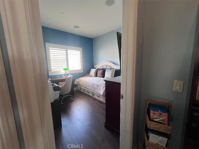 bedroom with dark hardwood / wood-style floors