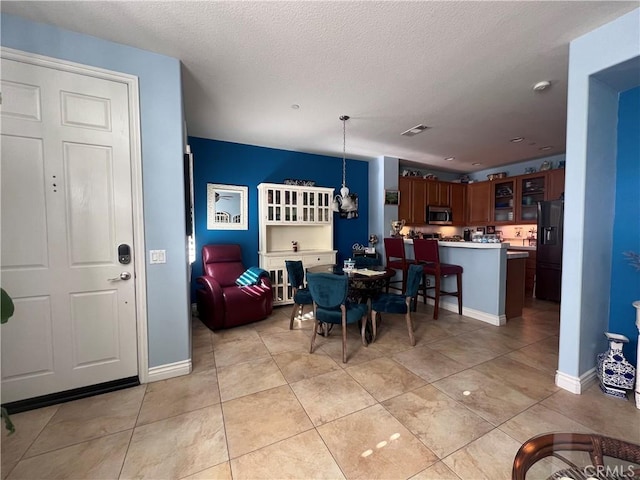 dining area with a textured ceiling and light tile patterned flooring