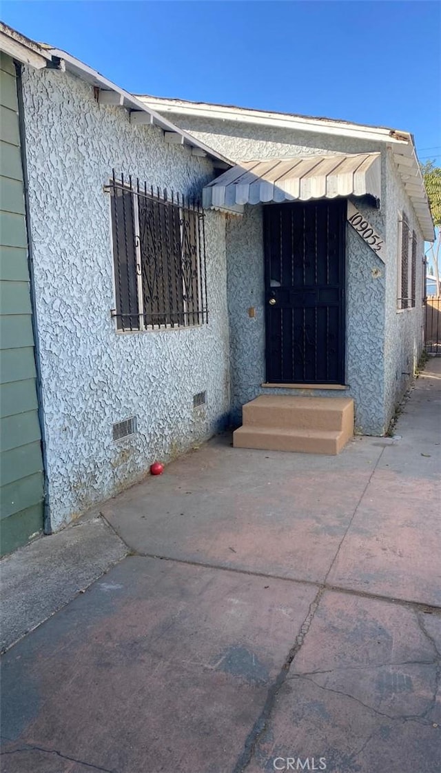 property entrance featuring a patio area