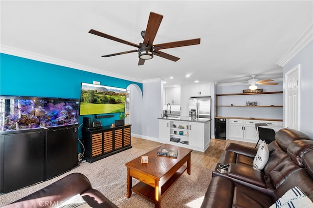 living room with ceiling fan, light hardwood / wood-style floors, sink, and crown molding