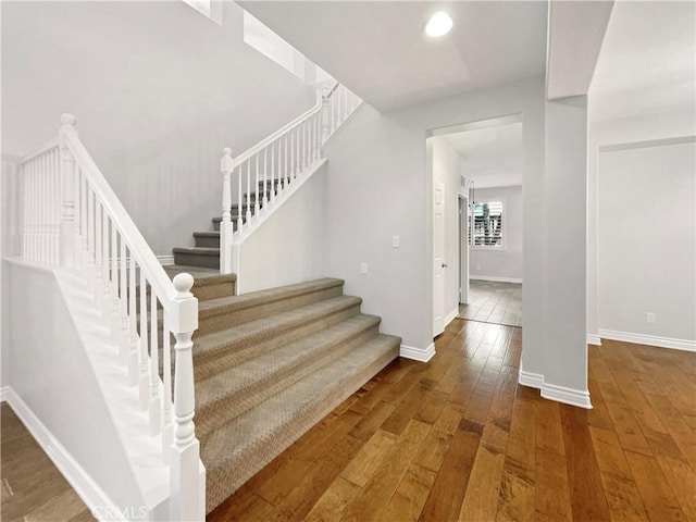 stairs featuring hardwood / wood-style floors