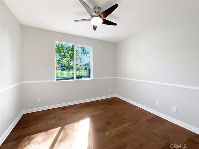 spare room with ceiling fan and dark hardwood / wood-style flooring