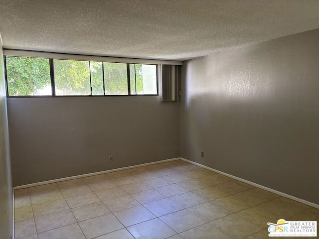 unfurnished room featuring a textured ceiling, a wealth of natural light, and light tile patterned flooring