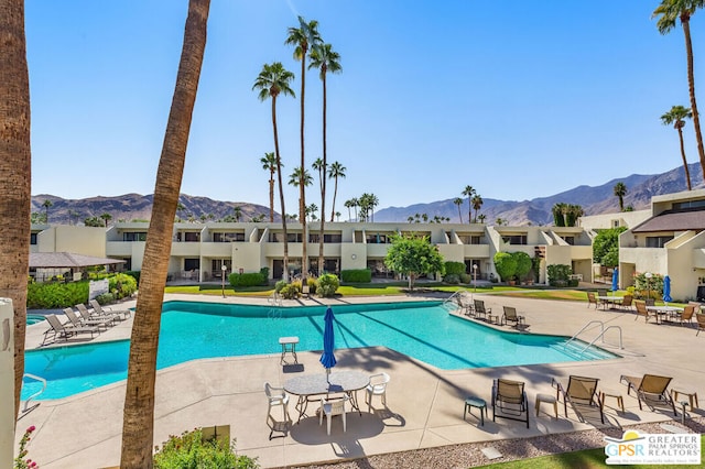 view of pool with a mountain view and a patio