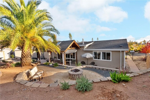 back of property with an outdoor fire pit and a patio area