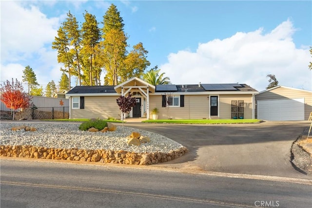 ranch-style house featuring a garage and solar panels