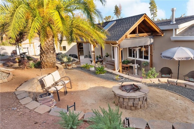 rear view of house featuring a patio and a fire pit