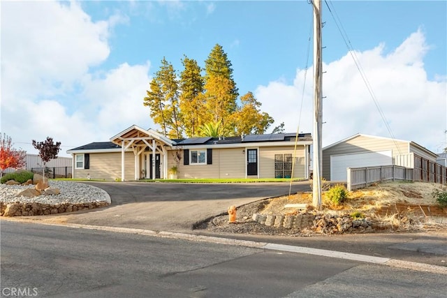 single story home with a garage and solar panels