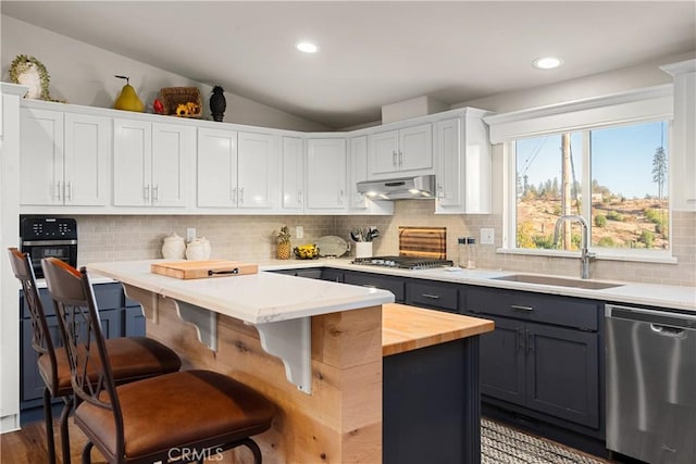 kitchen featuring white cabinetry, appliances with stainless steel finishes, a kitchen island, a breakfast bar, and sink