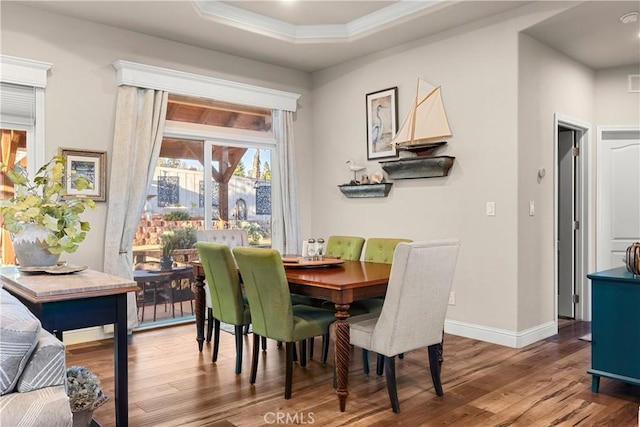 dining space with hardwood / wood-style flooring and a tray ceiling