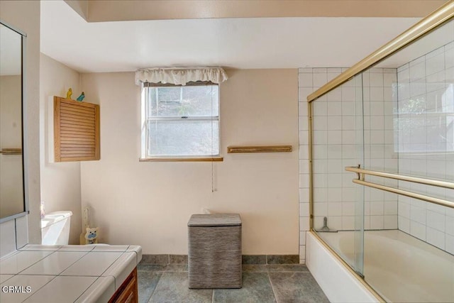 bathroom featuring tile patterned floors, vanity, and enclosed tub / shower combo