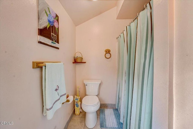 bathroom with tile patterned floors, toilet, and vaulted ceiling