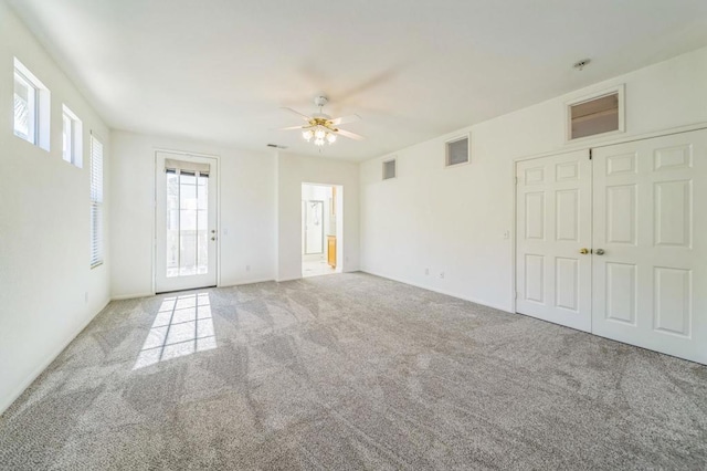 carpeted spare room featuring ceiling fan