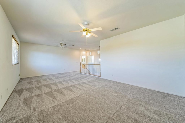 carpeted spare room with ceiling fan and plenty of natural light