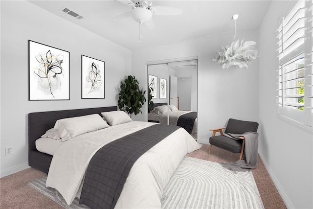 carpeted bedroom with ceiling fan and a closet