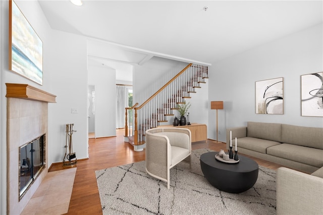 living room featuring a tile fireplace and wood-type flooring