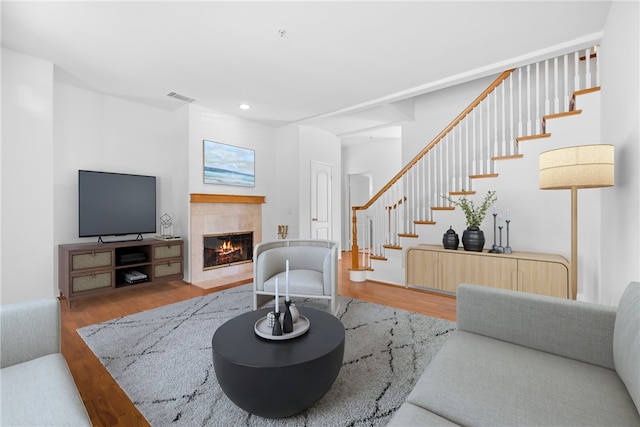 living room with light hardwood / wood-style floors and a tiled fireplace