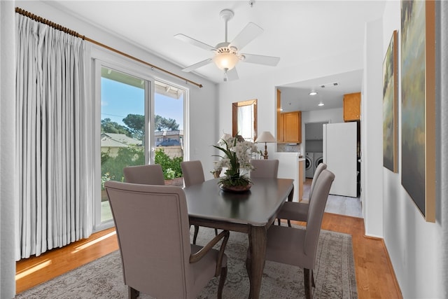 dining area with washer and clothes dryer, ceiling fan, and light hardwood / wood-style flooring