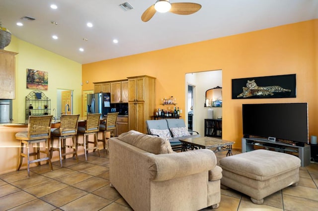 tiled living room with ceiling fan and lofted ceiling