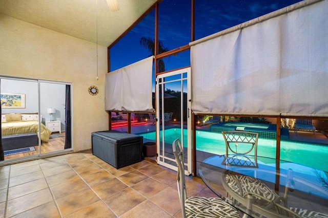 tiled bedroom with ceiling fan and high vaulted ceiling