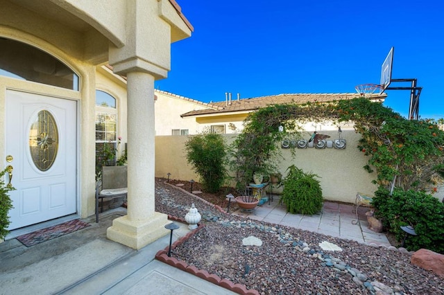 view of exterior entry with a patio area