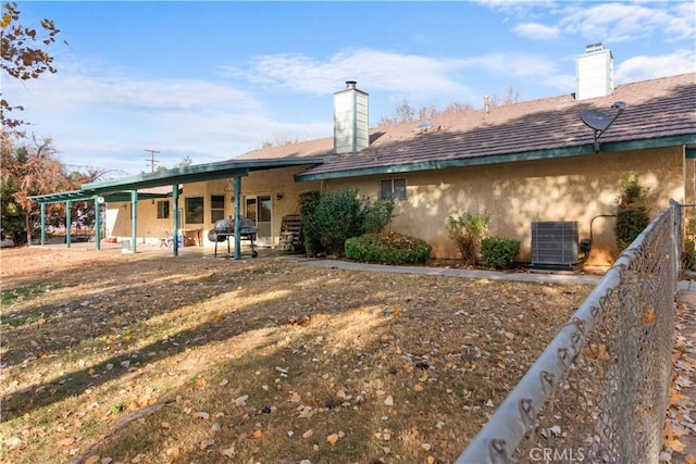 rear view of property featuring central air condition unit and a patio