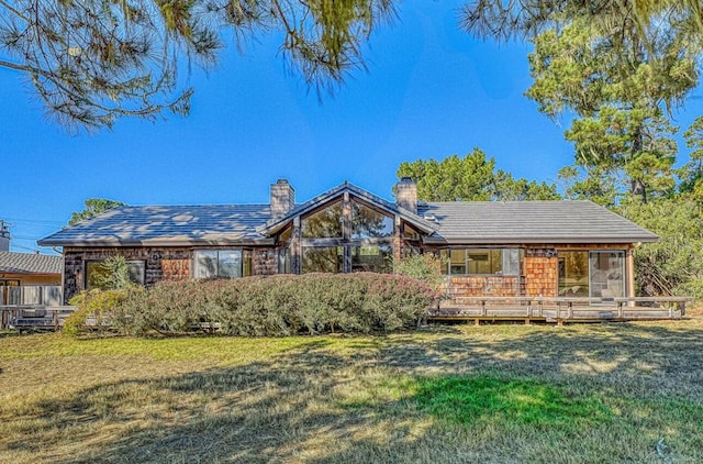 single story home with a front lawn and a deck