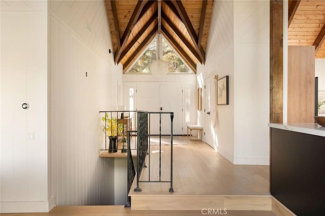 hallway featuring beam ceiling, wood ceiling, high vaulted ceiling, and light hardwood / wood-style flooring