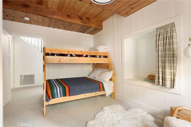 carpeted bedroom with wood walls, beamed ceiling, and wooden ceiling