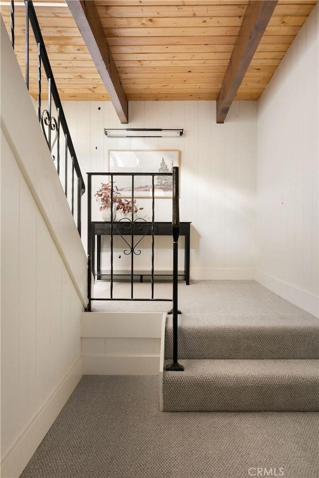 stairs with carpet, beamed ceiling, and wood ceiling