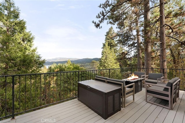 deck with a mountain view and an outdoor living space with a fire pit