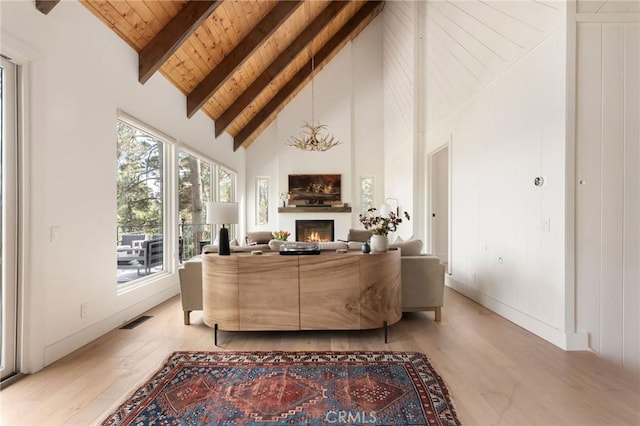 living room with beam ceiling, high vaulted ceiling, light hardwood / wood-style flooring, and wooden ceiling